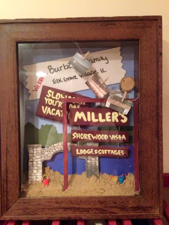 Homemade shadowbox diorama of the Miller's Shorewood Vista roadside sign, stone arch, sand, and beach toys